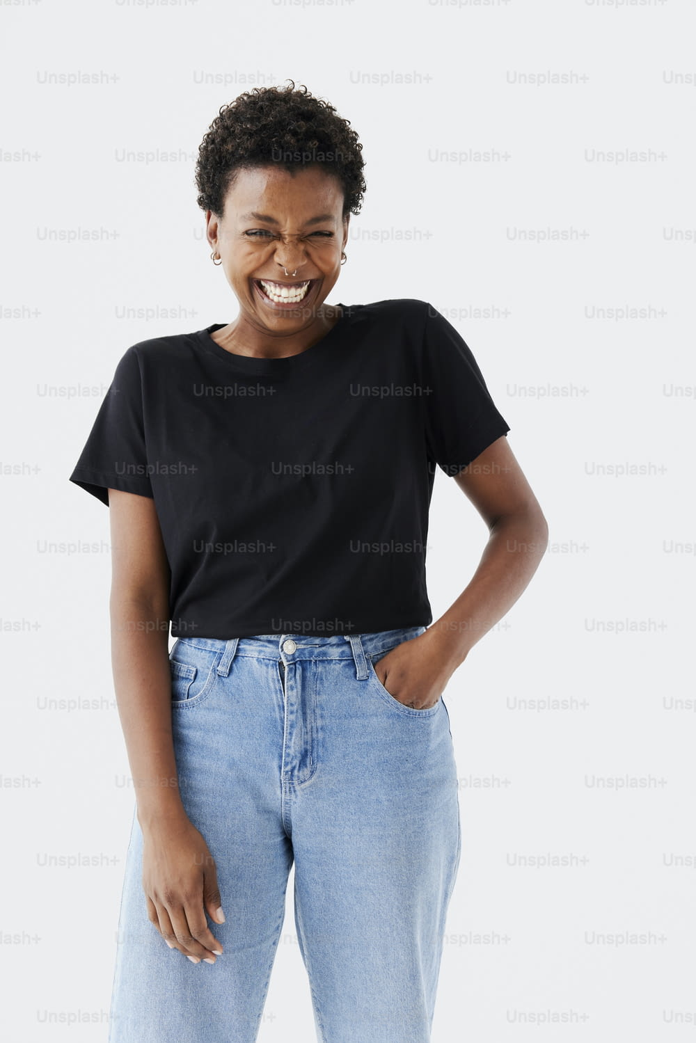uma mulher sorridente de camisa preta e calça jeans