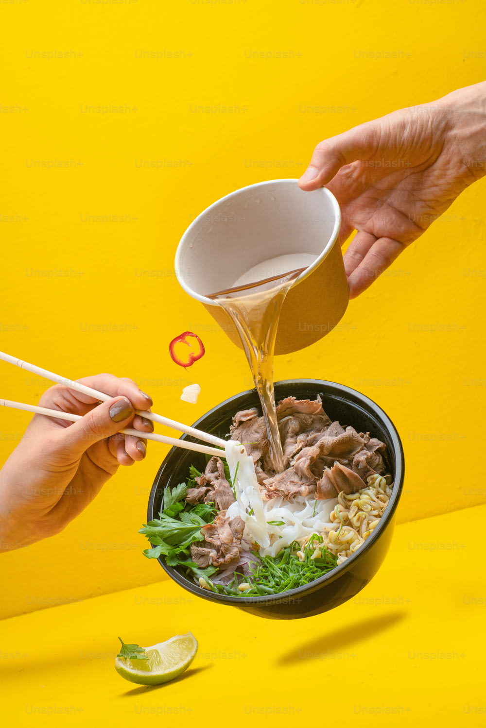 a bowl of food with chopsticks being poured into it