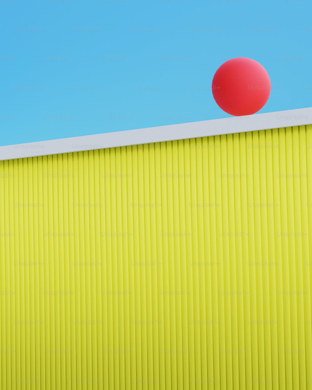 a red ball sitting on top of a yellow wall