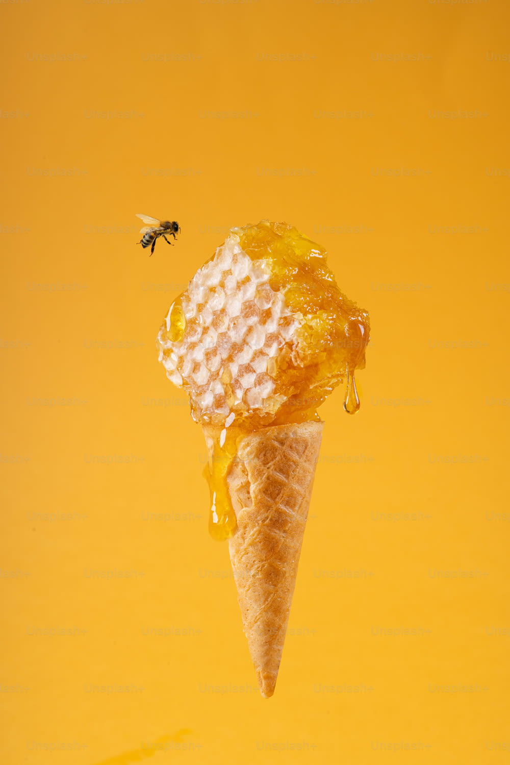 uma casquinha de sorvete com favos de mel e uma abelha
