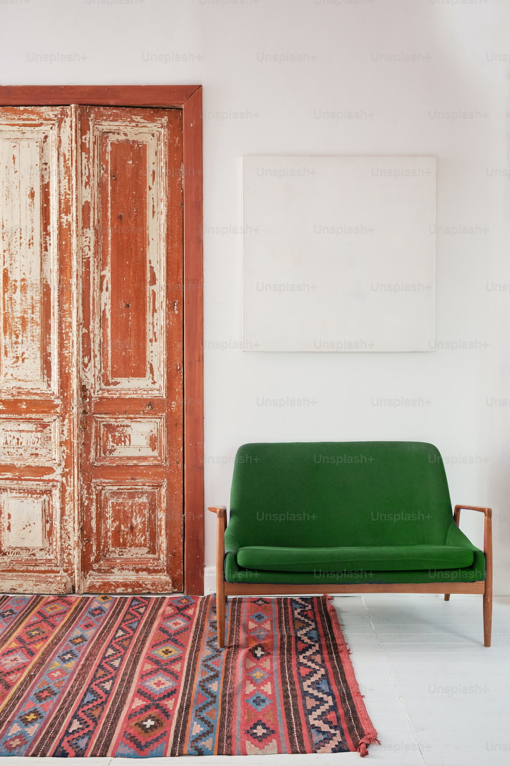 a green couch sitting in front of a wooden door