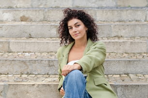 Eine Frau, die mit gekreuzten Beinen auf einigen Stufen sitzt