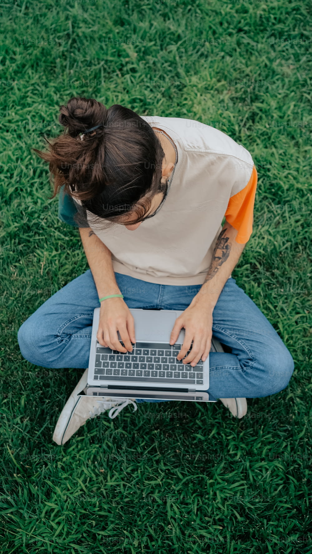 a person sitting in the grass with a laptop
