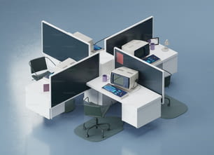 un cubículo de oficina con tres monitores y un ordenador