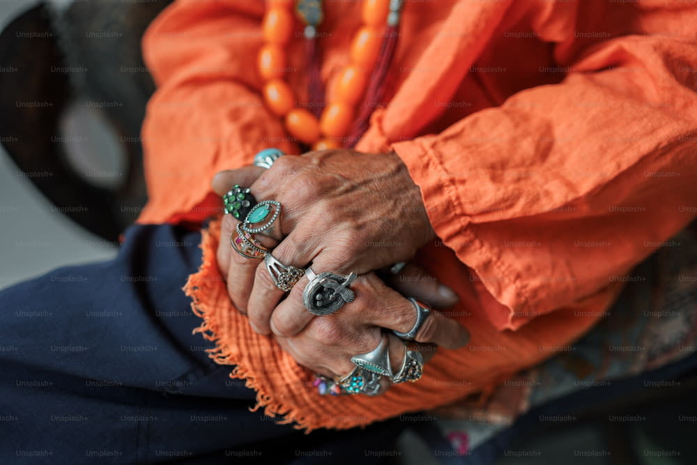 a close up of a person with rings on their hands
