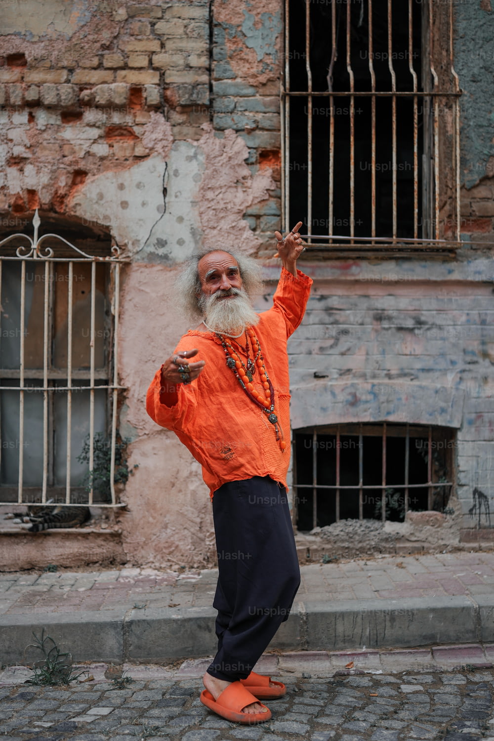 um homem com uma longa barba branca e camisa laranja