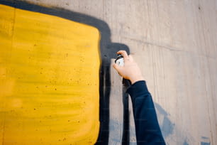 a person is painting a yellow and black wall