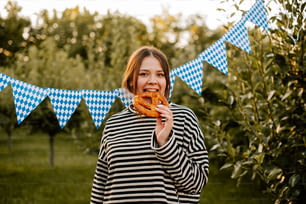 uma mulher está comendo uma rosquinha em um campo