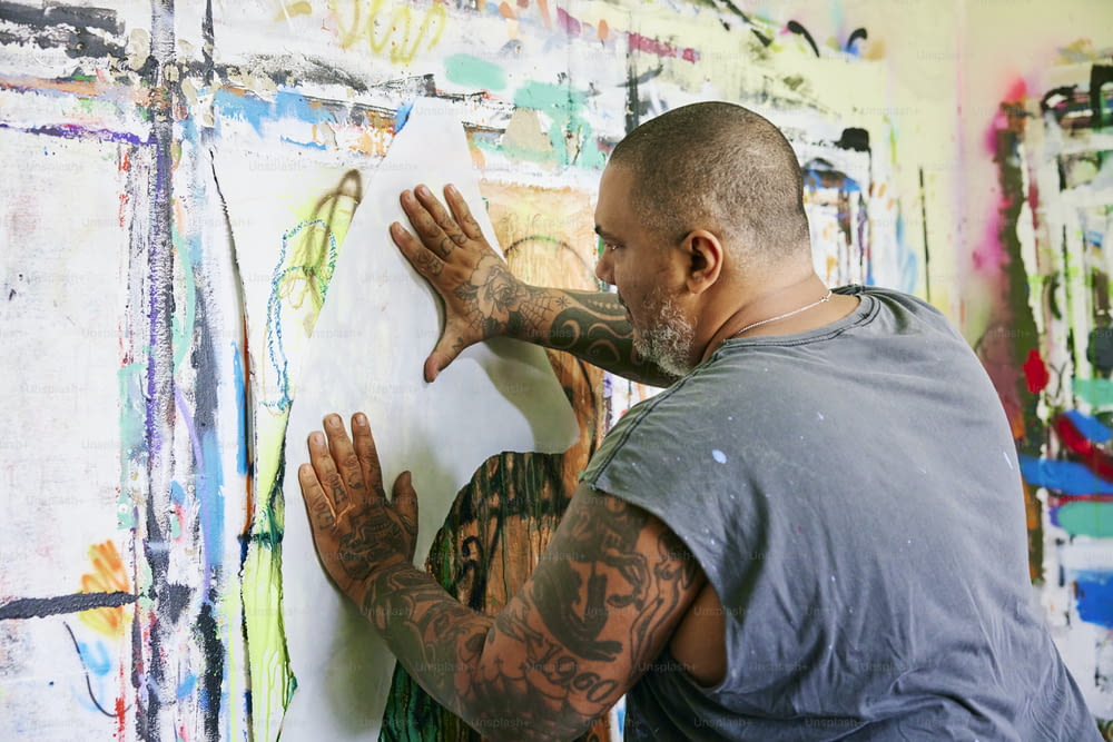 Ein Mann malt mit seinen Händen auf eine Wand