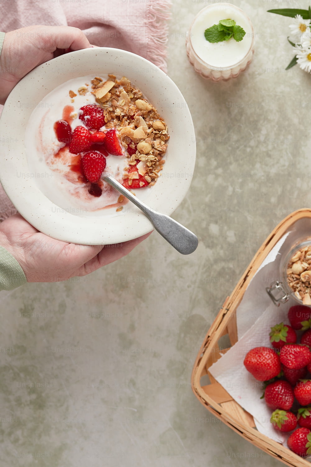 une personne tenant un bol de granola et de fraises