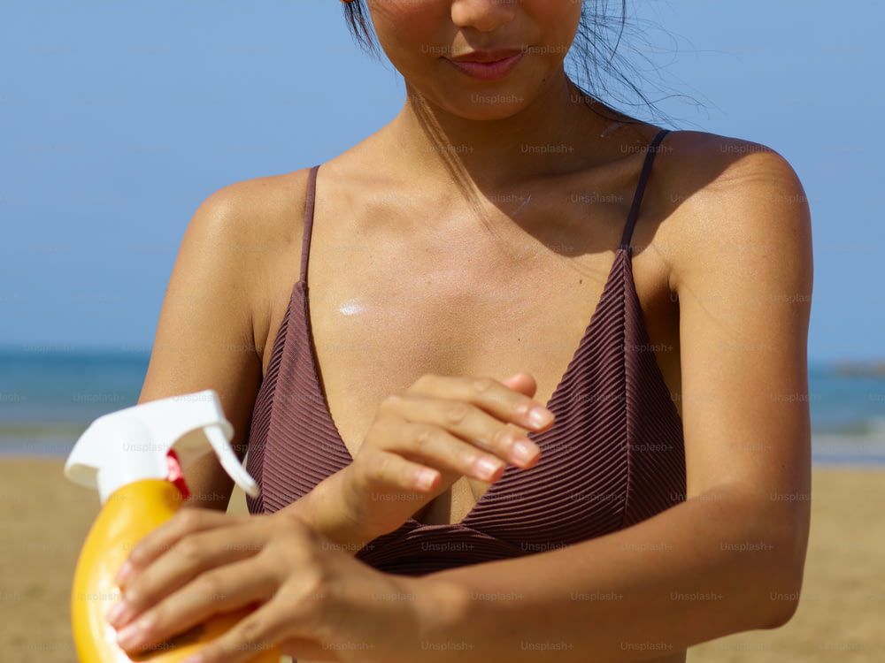 Una mujer en bikini sosteniendo un frisbee amarillo