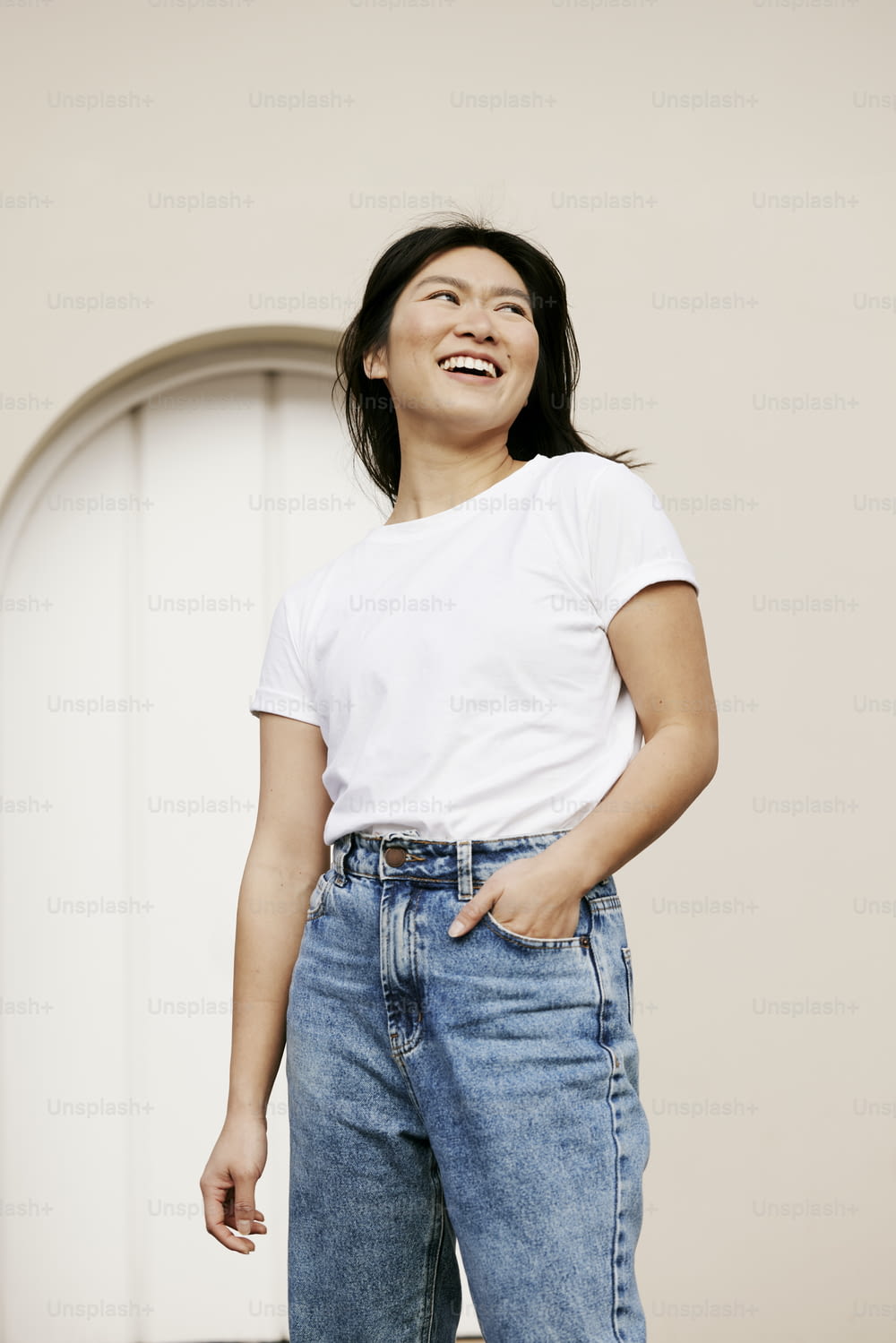 a woman in a white shirt and jeans laughing