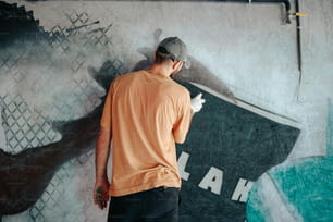 Un homme debout devant une peinture murale