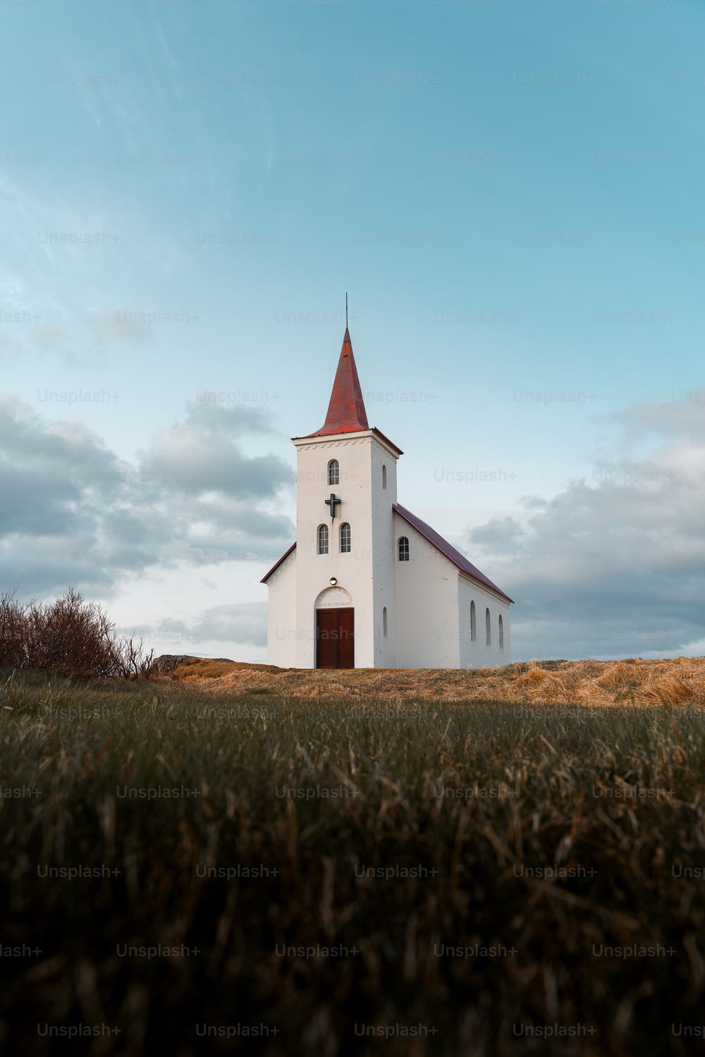 eine weiße Kirche mit rotem Kirchturm auf einem Hügel