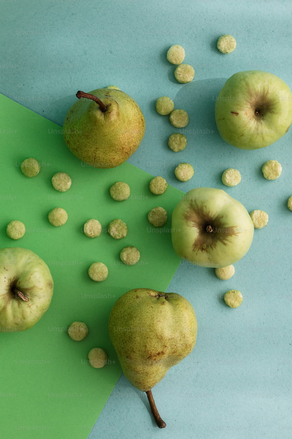 a group of apples sitting on top of a green and blue surface