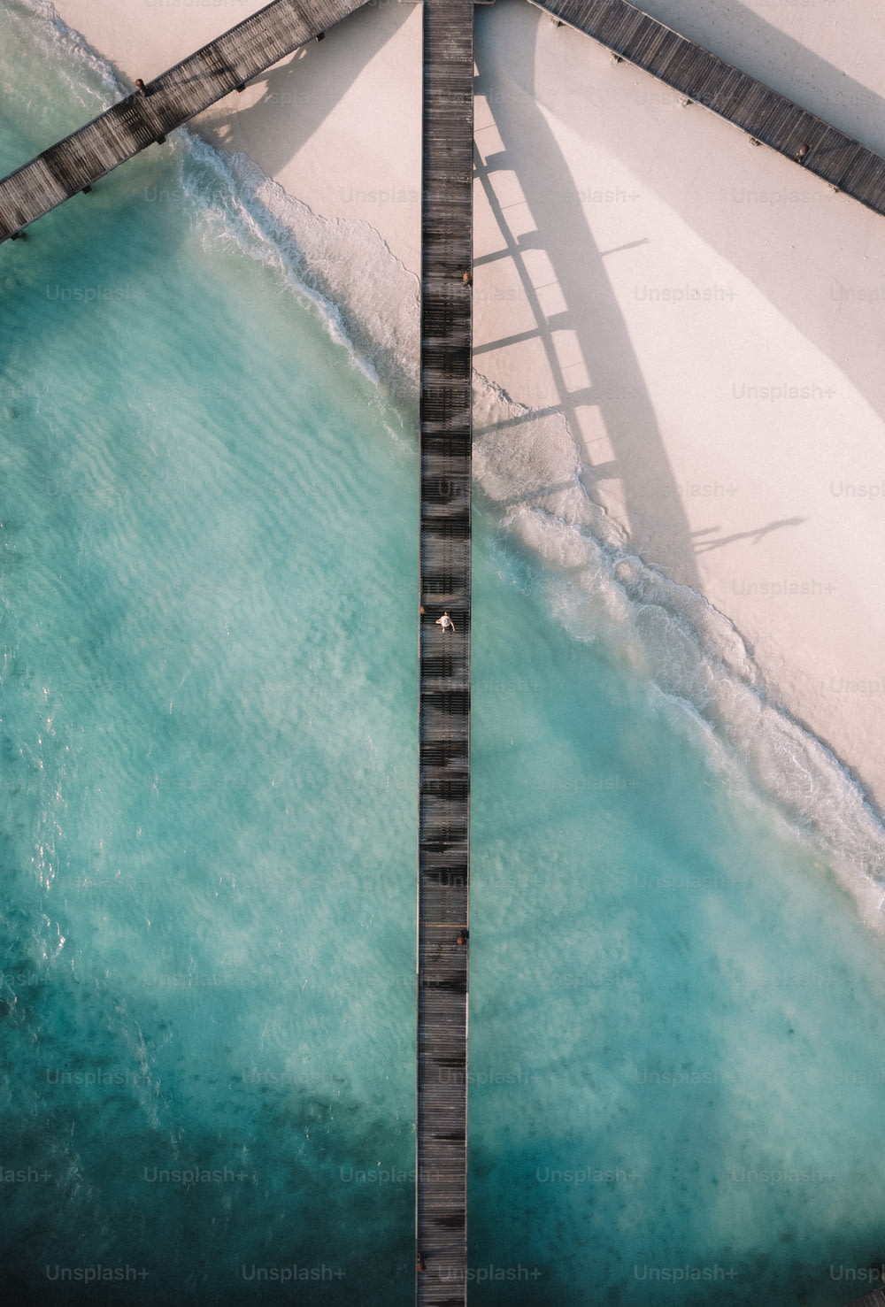 un ponte su uno specchio d'acqua vicino a una spiaggia