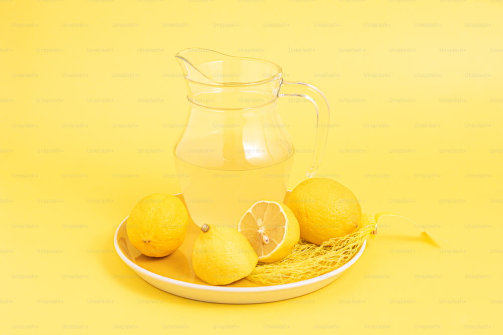 접시에 물 한 주전자와 레몬 몇 개