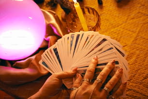 Una donna che tiene un mazzo di carte accanto a una candela