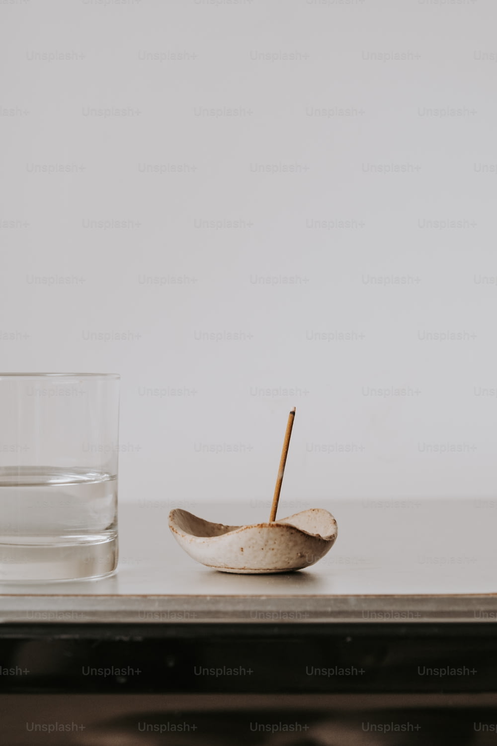 a glass of water and a wooden spoon on a table