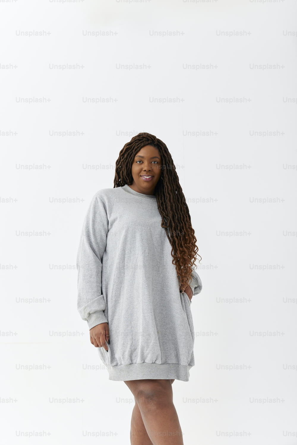 a woman in a gray sweater dress posing for a picture