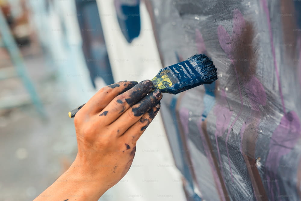a person painting a wall with a paintbrush