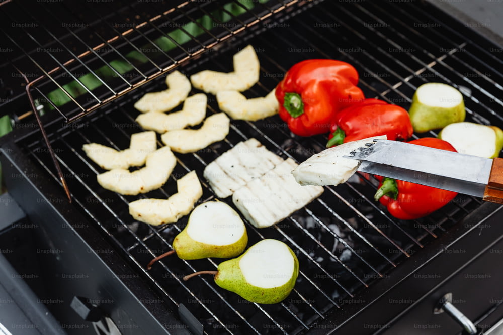 a person is cutting apples and vegetables on a grill