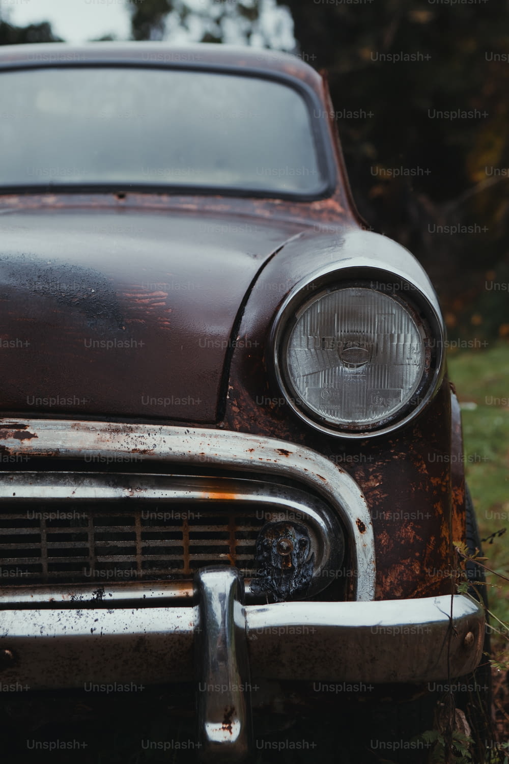 Un viejo coche oxidado sentado en un campo