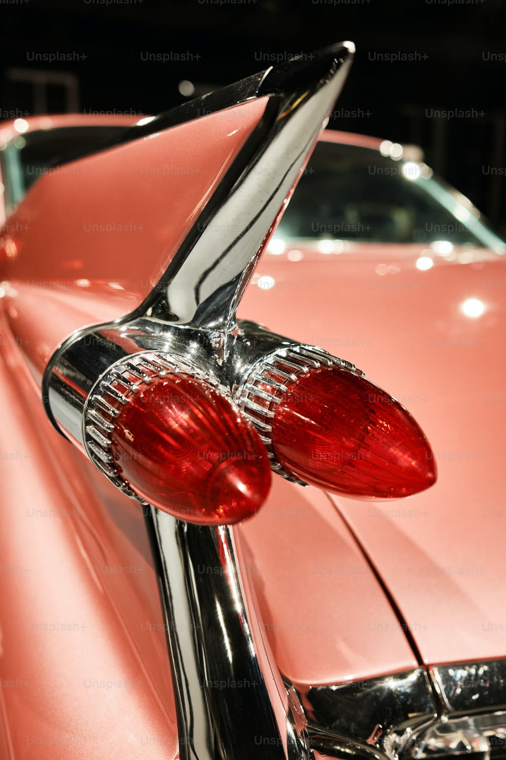 a close up of the tail lights of a pink car