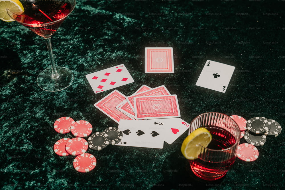 un bicchiere di vino e carte da gioco su un tavolo