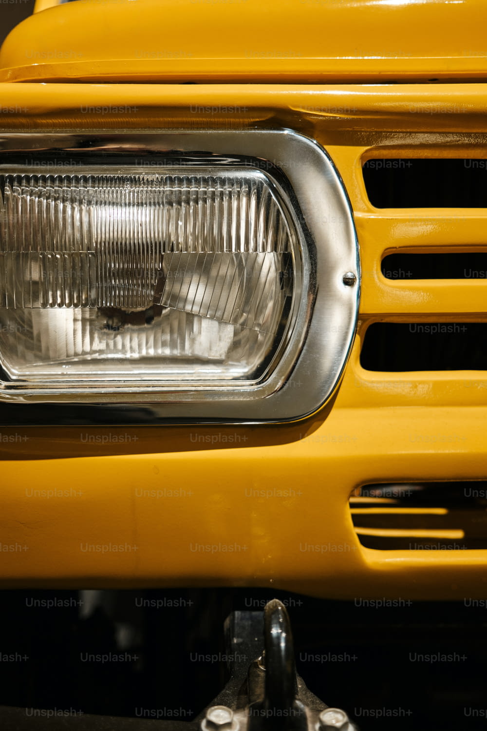a close up of a headlight on a yellow truck