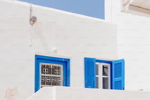 Un edificio bianco con persiane blu e un orologio