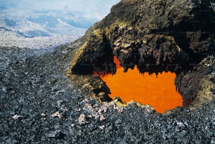 an orange substance in the middle of a rocky area