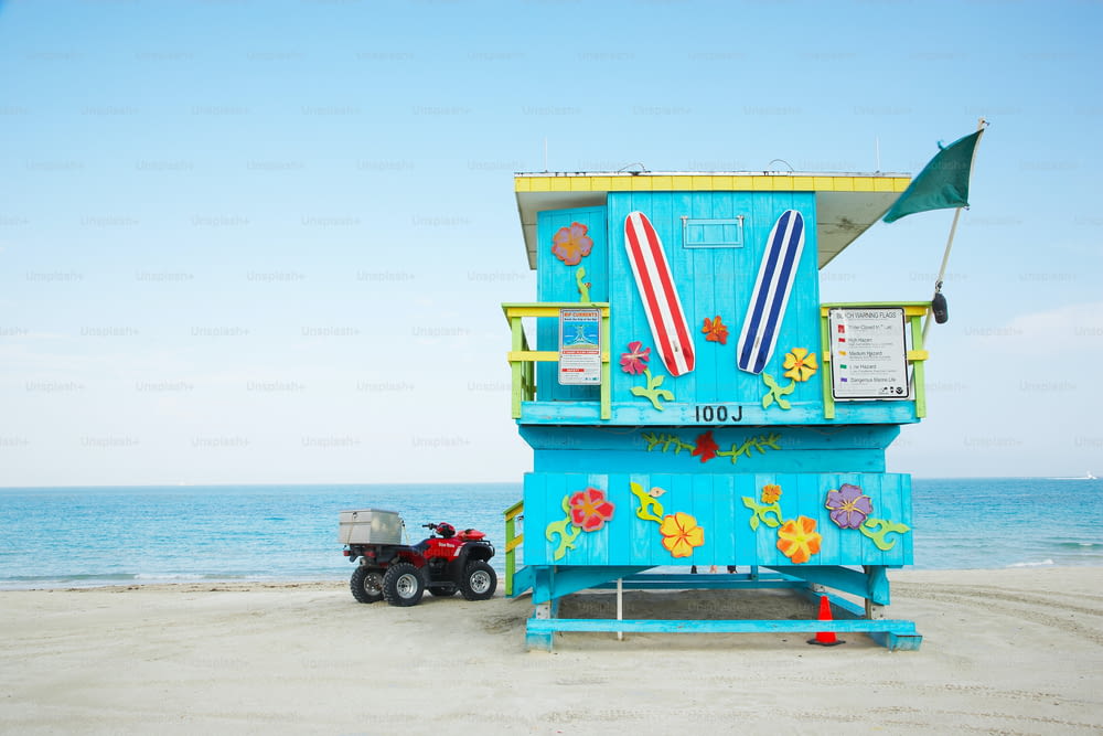 a lifeguard stand on the beach with a toy truck parked in front of it