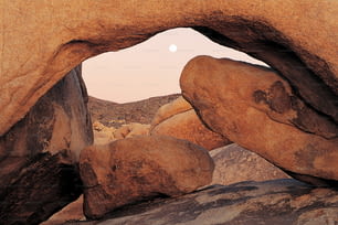 a rock formation with a full moon in the background