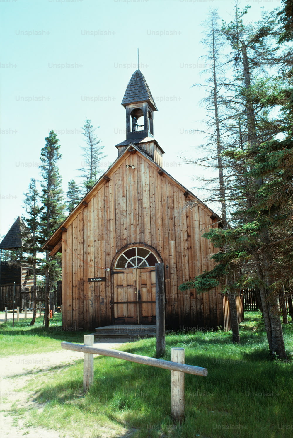 a wooden church with a steeple and a clock tower