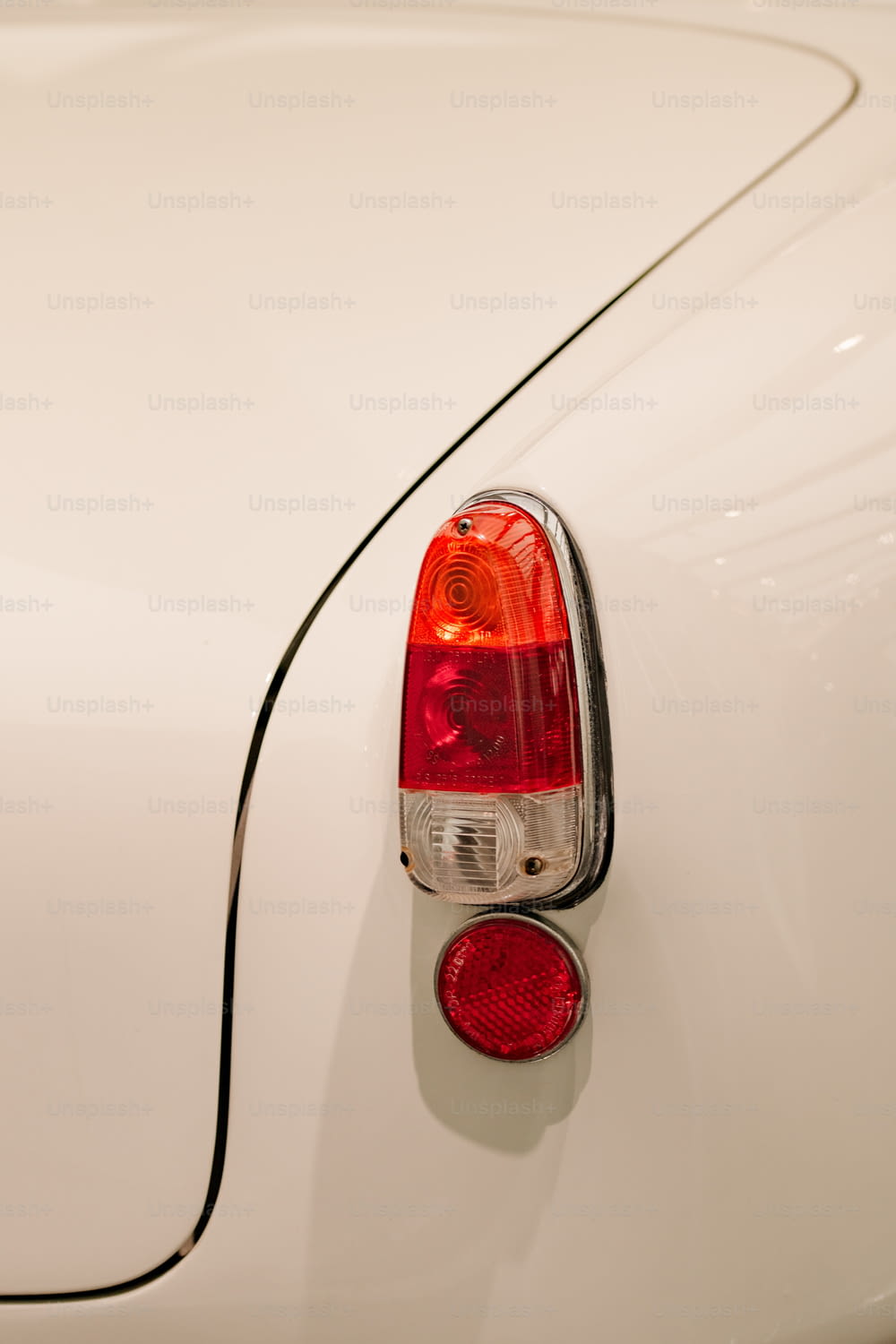um close up de um carro branco com uma luz vermelha