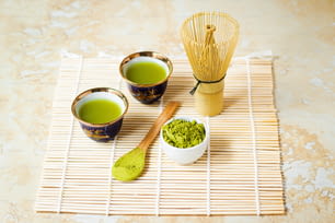 three cups of green tea on a bamboo mat