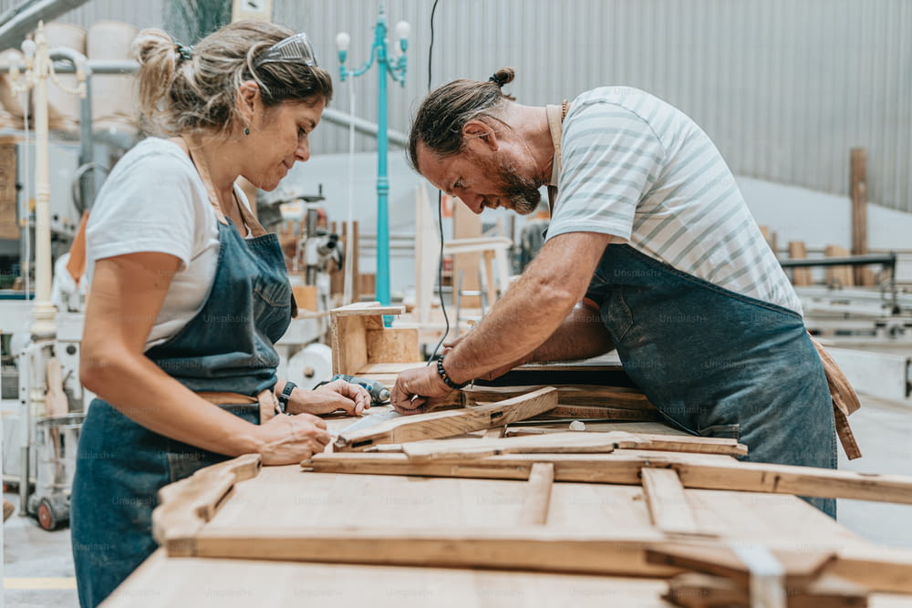 Ein Mann und eine Frau arbeiten an einem Stück Holz