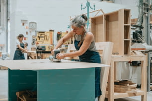 a woman working on a piece of furniture