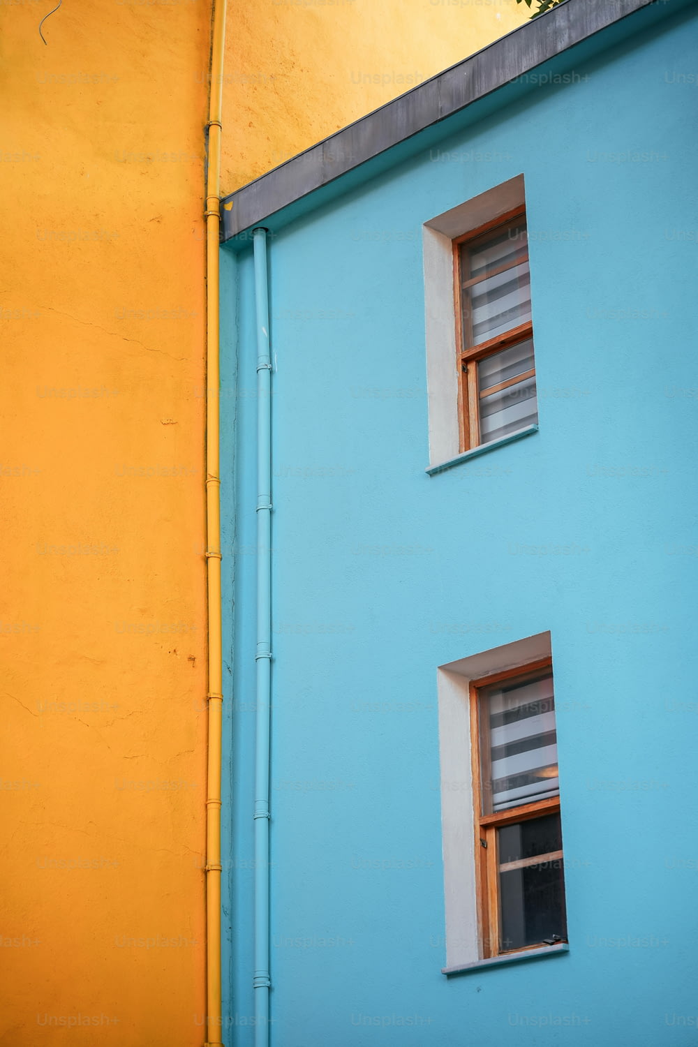 a blue and yellow building with two windows