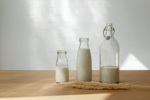 a wooden table topped with two bottles of milk