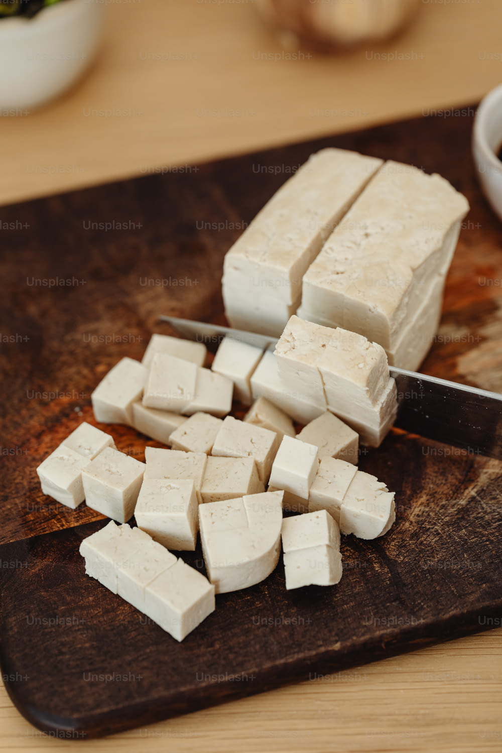 a cutting board with cubes of tofu on it