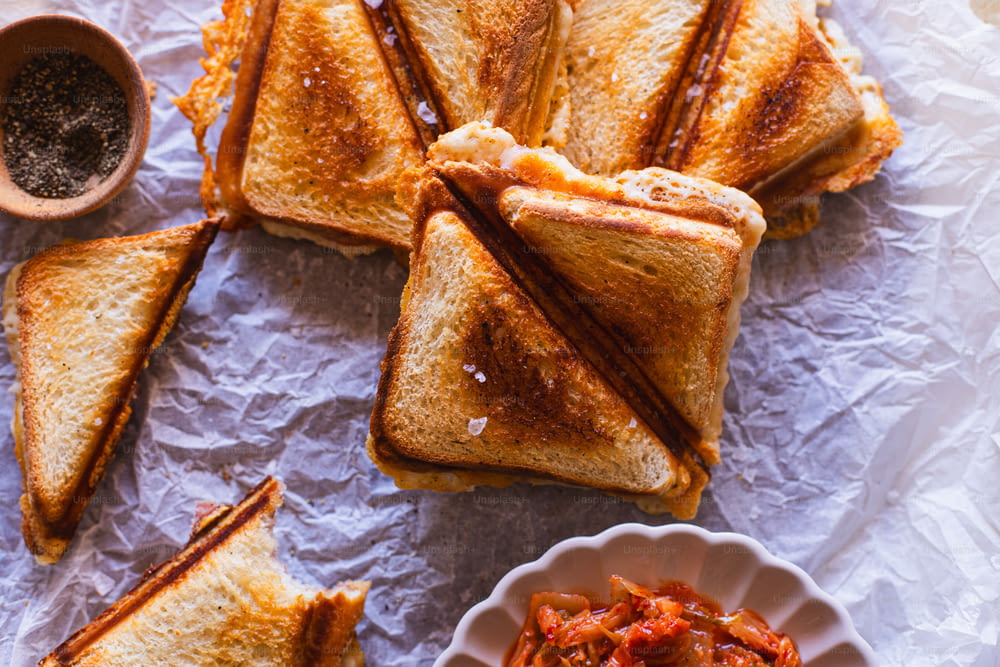 a plate of toasted sandwiches and a bowl of chili