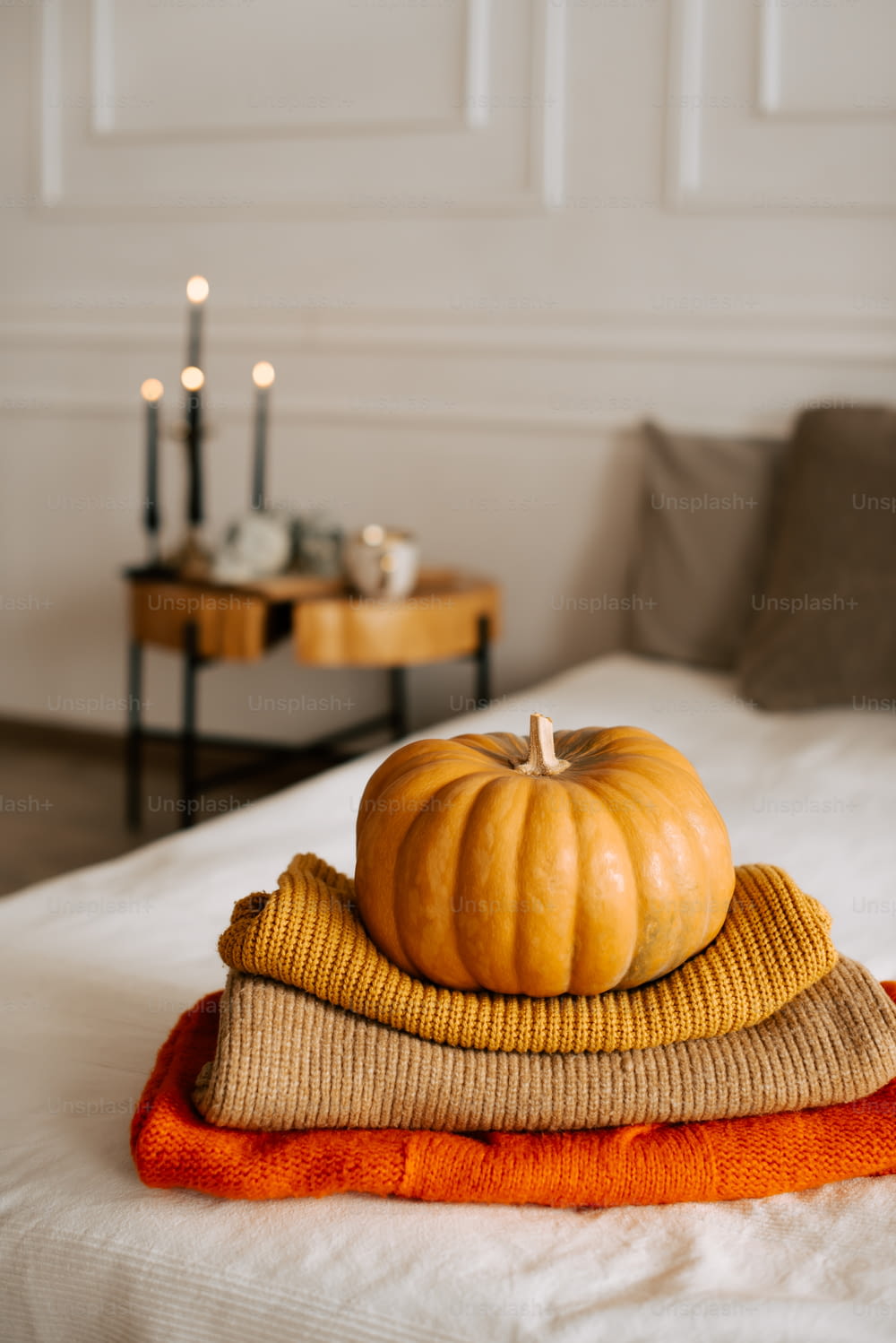 a stack of pumpkins sitting on top of a bed