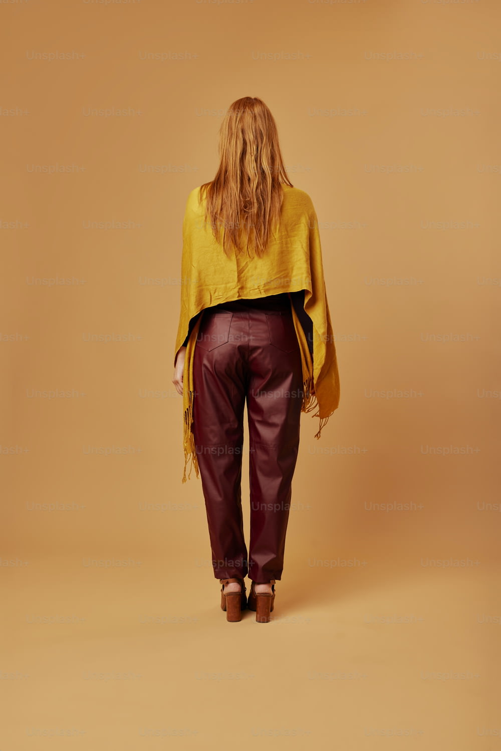 Eine Frau in einem gelben Oberteil und einer kastanienbraunen Hose