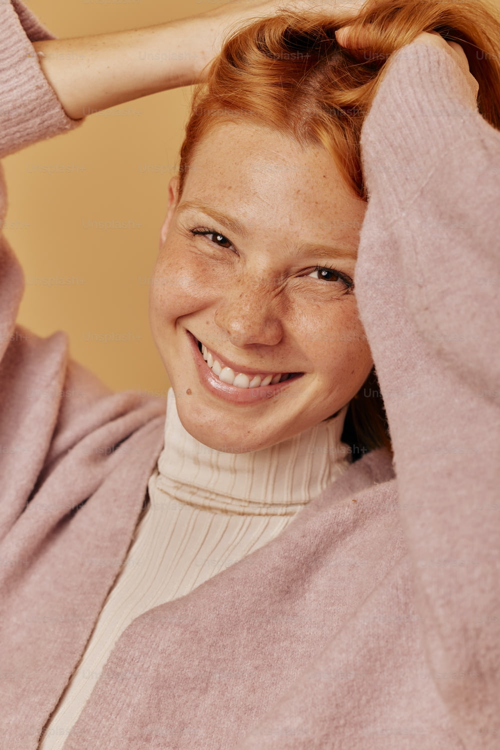 Uma mulher com cabelos ruivos está sorrindo para a câmera