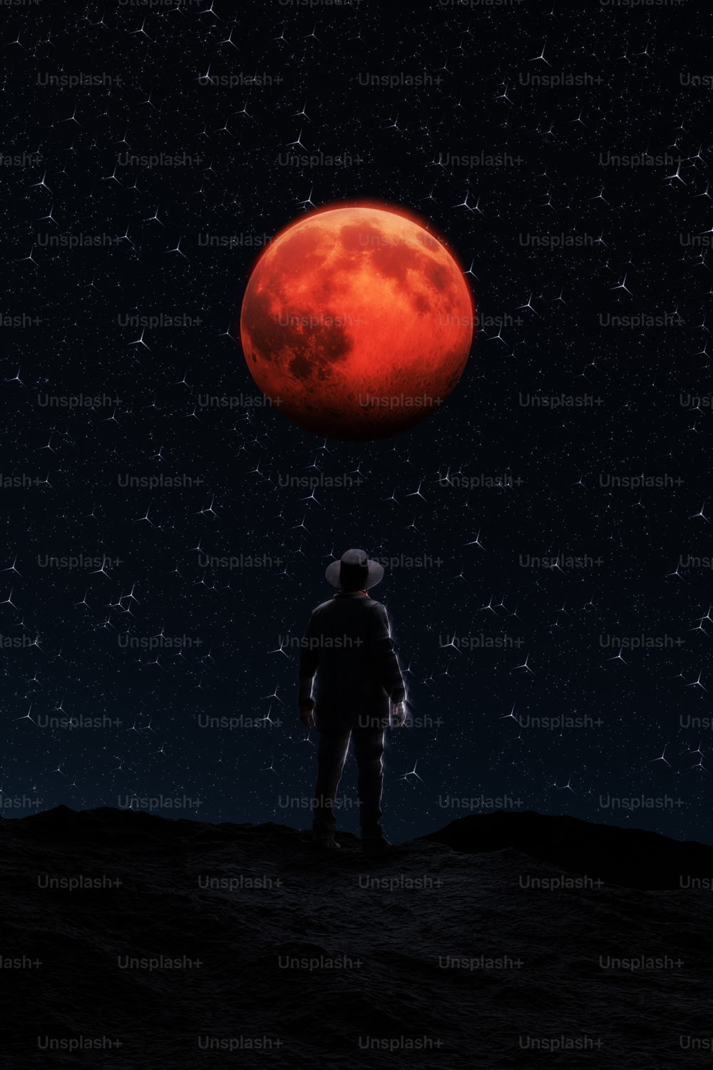 Ein Mann, der auf einem Hügel unter einem roten Mond steht