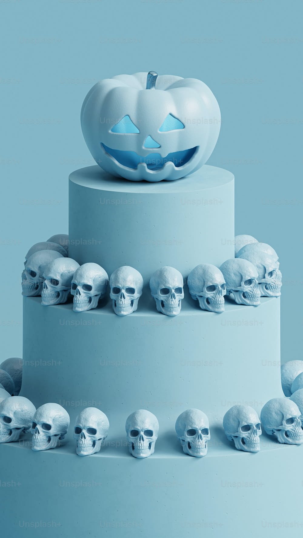 a three tiered cake with skulls and a pumpkin on top