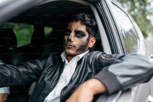 a man with face paint sitting in a car