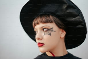 a woman wearing a black hat with a spider on it